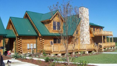 Forest green rib roofing over a log cabin