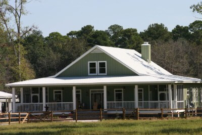 Wide front yard of a green-colored house with Galvalume rib roofing