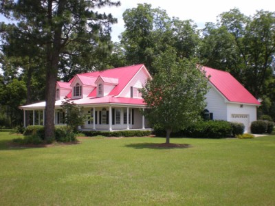 Old farm red metal roofing over a white house